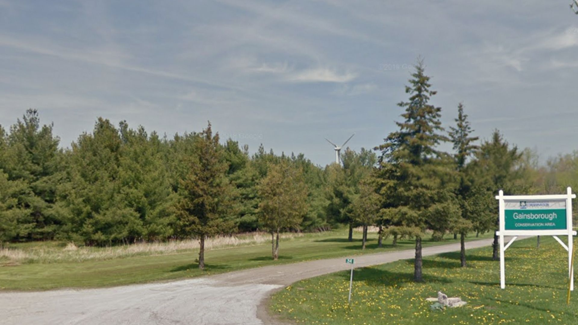 Park entrance with dirt road and greenery