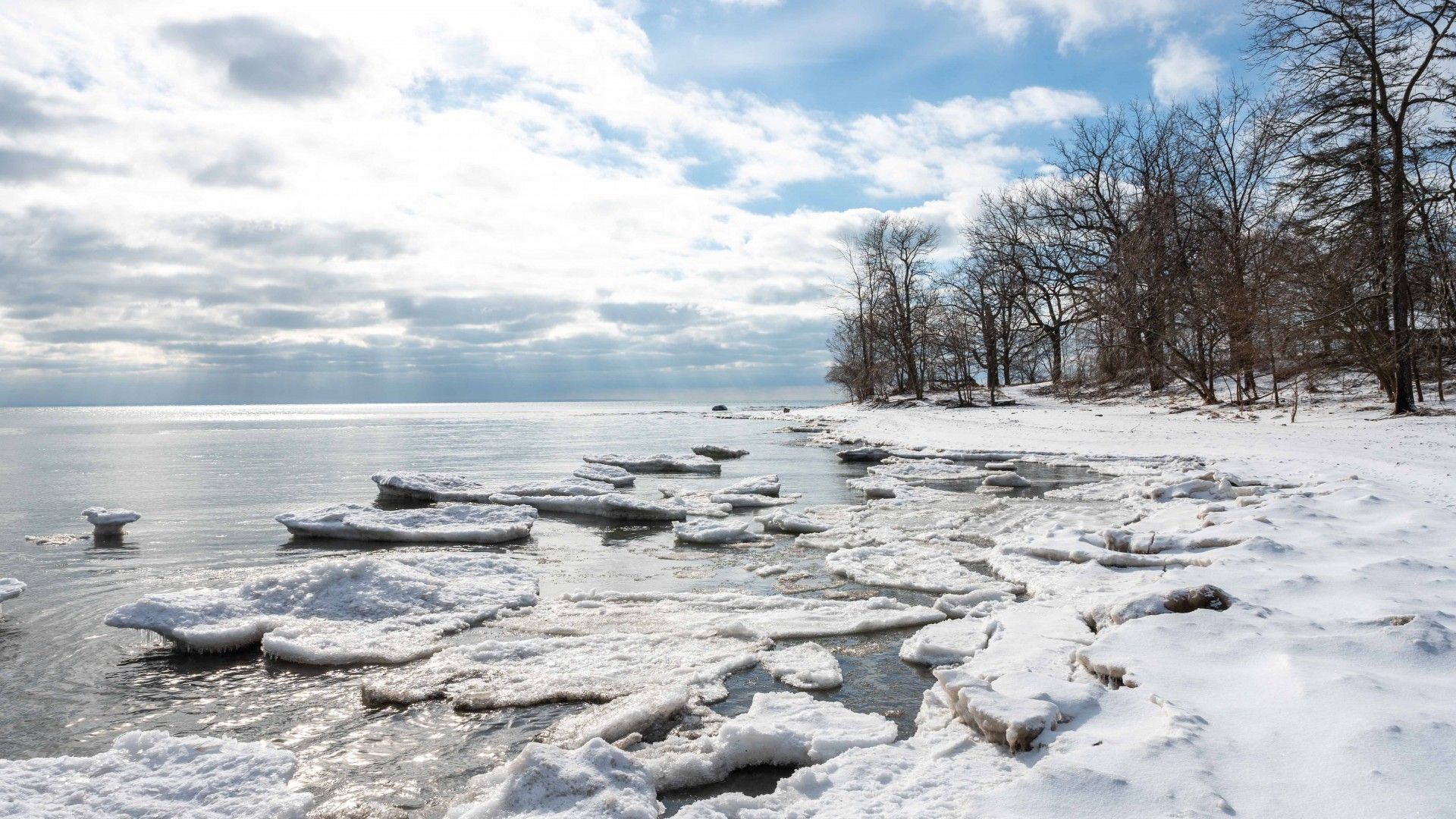 A sunny winter day on Lake Erie, with snow covering the beach.
