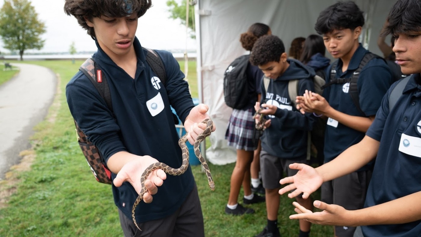 A student holds a snake.