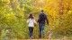 couple walking trail in the fall with dog