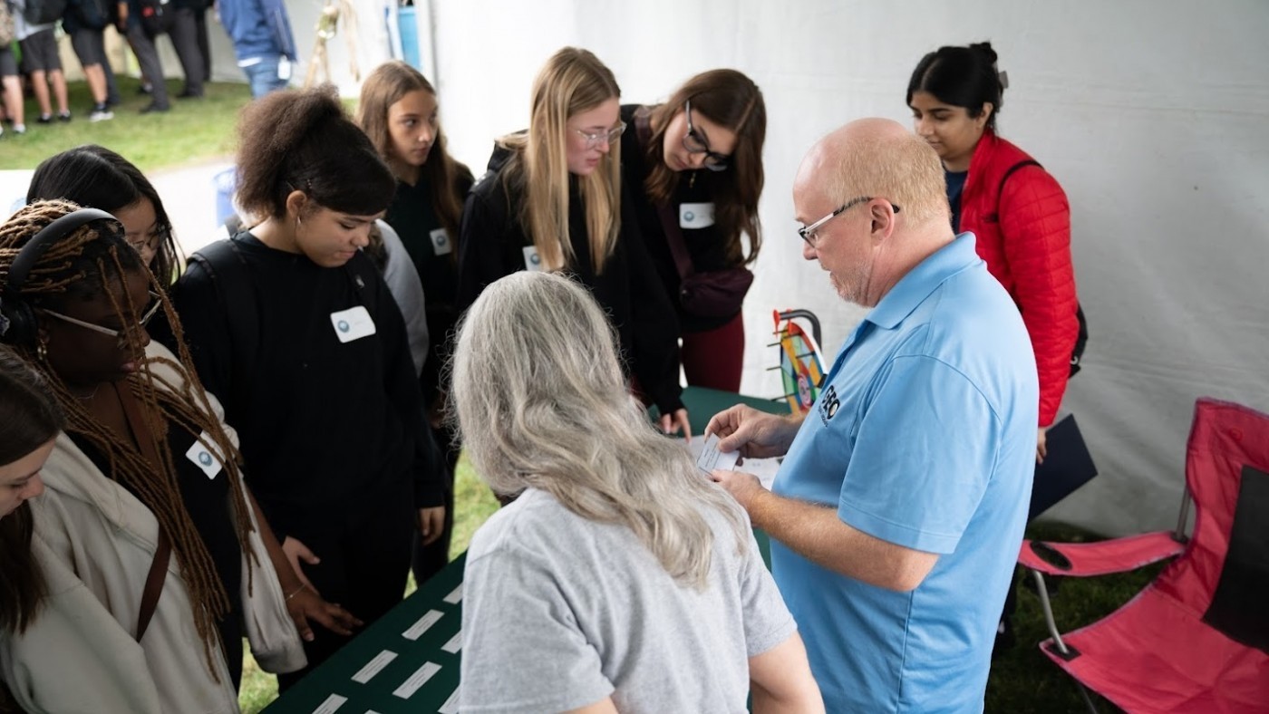 A group of students gather around a table.