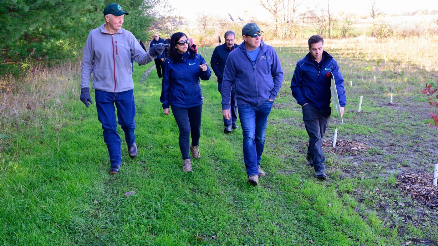 Various partners walk around property where restoration project took place