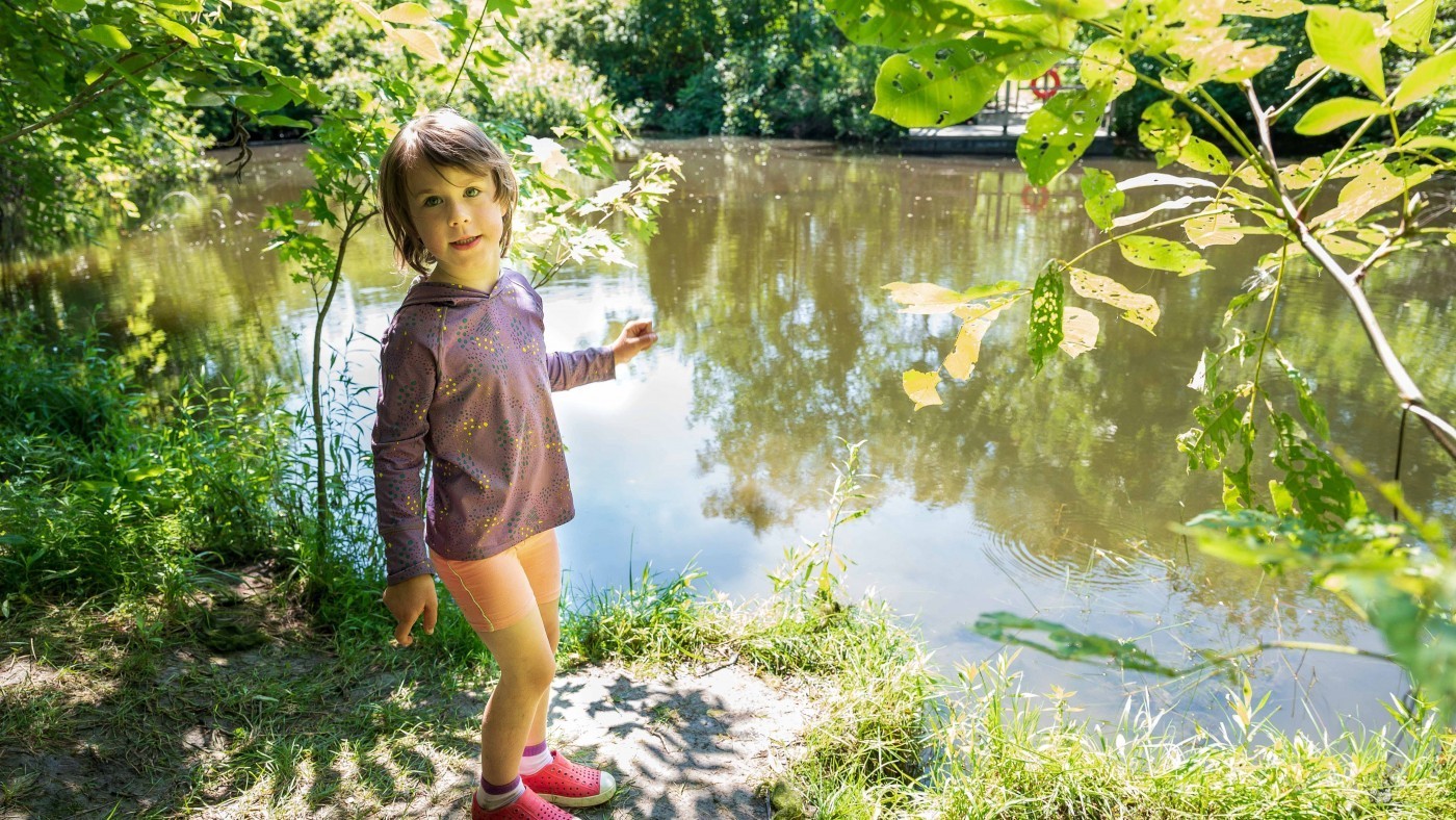 child playing by pond in conservation area