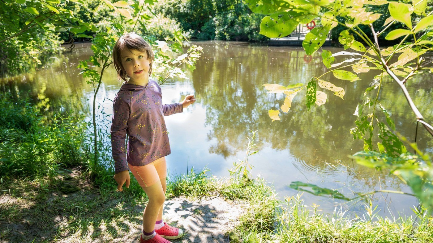 Child playing by pond in conservation area