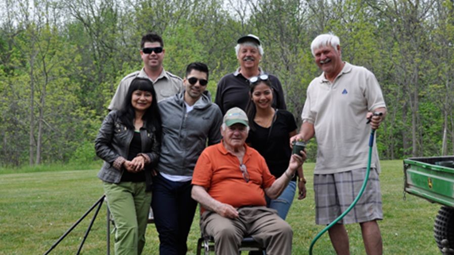 Group of individuals posing in green field